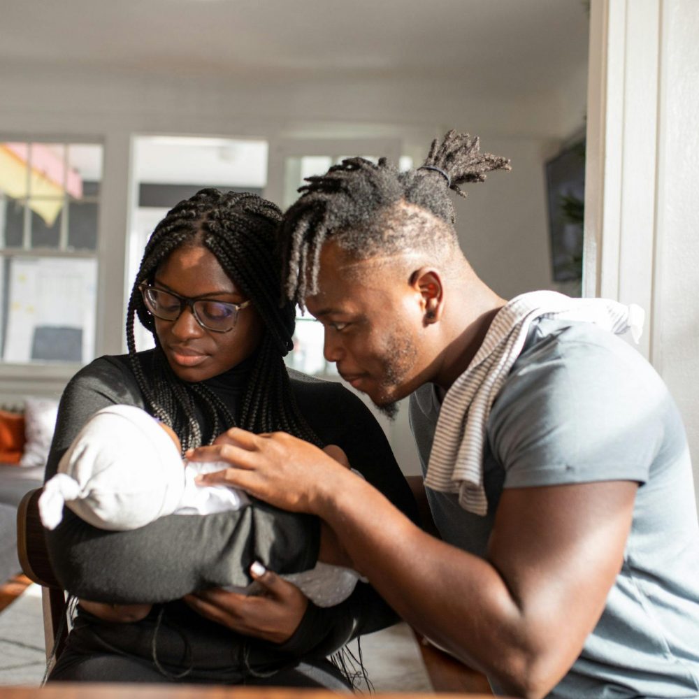 Loving parents embracing their newborn baby at home, capturing a tender family bond.