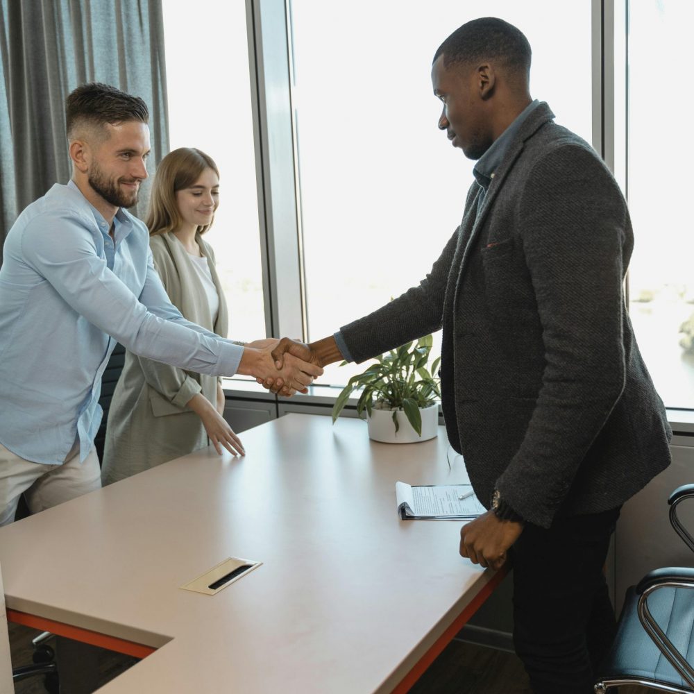 Professional handshake between colleagues in a modern office setting.